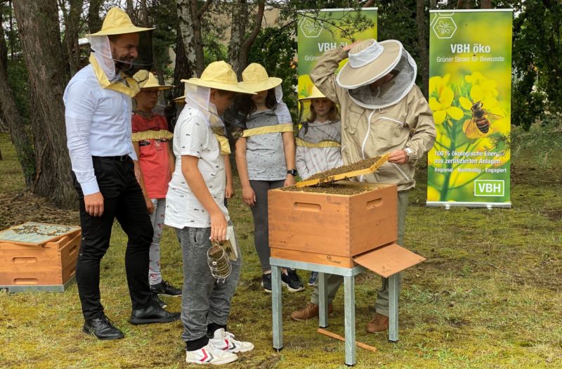 Imker mit Schülergruppe am Bienenstock auf der Freifläche der Kläranlage Hoyerswerda