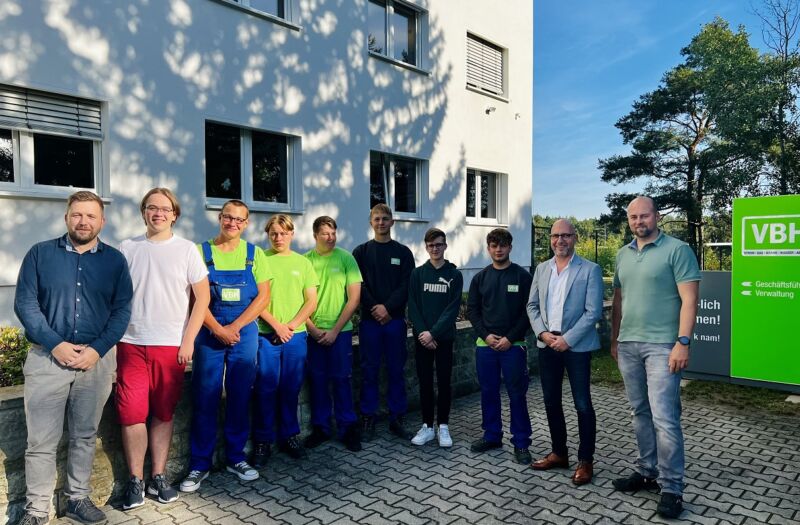 Sechs junge Auszubildende sowie ein BA-Student mit der Geschäftsführung vor dem Verwaltungsgebäude der VBH