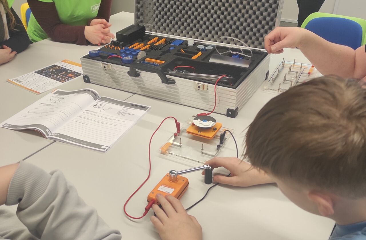 Das Bild zeigt Schulkinder, der siebten Klasse, welche Versuche mit Strom durchführen.