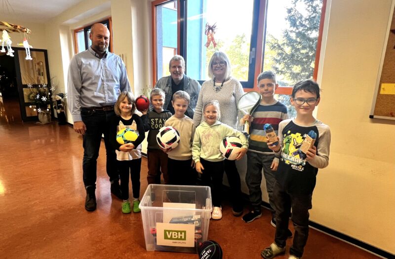 Schüler der 1. und 2. Klasse der Grundschule Burgneudorf freuen sich gemeinsam mit Schulleiterin Karin Weiß (m.) und Frank Richter (2.v.l.), Vertreter des Kindersprints, über die VBH-Sportmaterialkiste, die VBH-Prokurist Jan Schulze (l.) übergab.